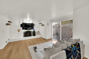 Living area featuring wood finished floors and a brick fireplace