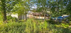 Rear view of house with a deck, a patio, and an outbuilding
