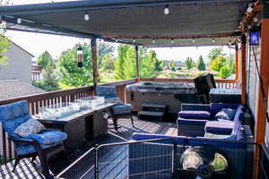 Wooden terrace with a hot tub and outdoor dining space