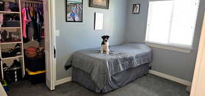 Bedroom with dark carpet and a closet