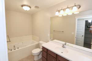 Primary suite bathroom with a garden tub, separate shower, tile floors, and large vanity