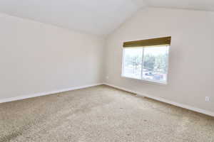 Large primary suite bedroom with vaulted ceiling