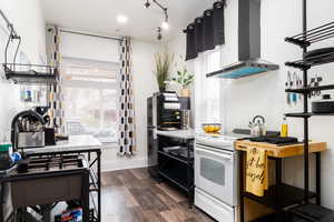 Kitchen with open shelves, island exhaust hood, electric range, dark wood-style flooring, and rail lighting