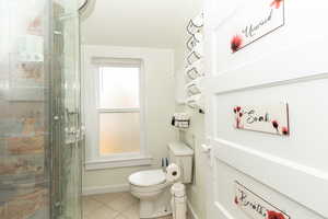 Bathroom featuring tile patterned floors and a stall shower