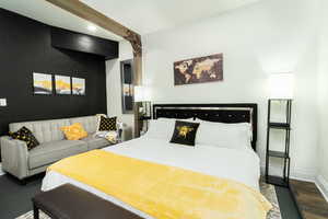 Bedroom with dark wood finished floors and radiator heating unit