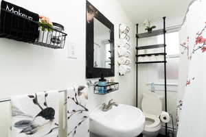 Bathroom with a textured ceiling and a baseboard heating unit