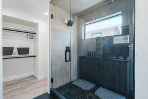 Full bath with a stall shower, wood finished floors, and recessed lighting