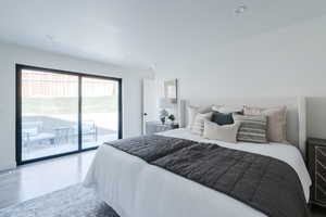Bedroom with access to exterior, wood finished floors, and recessed lighting
