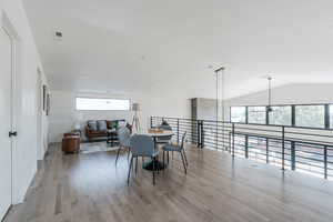 Dining room featuring light wood finished floors and vaulted ceiling
