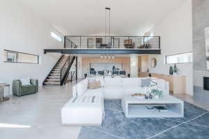 Living area featuring high vaulted ceiling, wood finished floors, and a fireplace