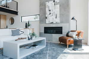Living area with a tiled fireplace and a high ceiling