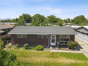 View of front facade with brick siding and a shingled roof