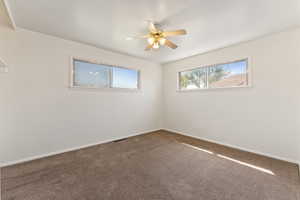 Carpeted bedroom room featuring baseboards and ceiling fan
