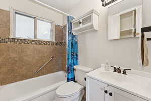 Bathroom featuring shower / bath combo with shower curtain and vanity