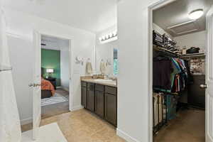 Bathroom featuring vanity, connected bathroom, and a walk in closet
