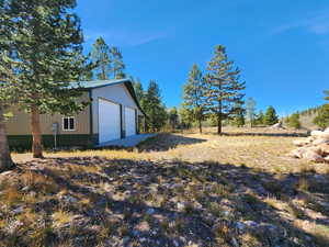 View of yard with an outbuilding and a garage