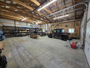 Garage with a workshop area, metal wall, and a garage door opener