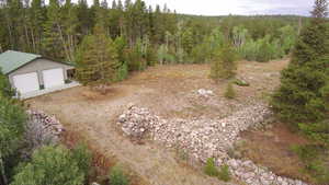 Aerial view of property and surrounding area with a forest