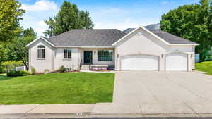 Ranch-style house with stucco siding, a garage, driveway, and roof with shingles