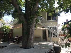 Back of house with stairway, a deck, and outdoor dining space