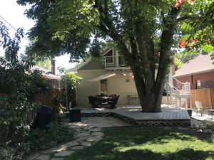 Rear view of house with a patio area, stairs, and a deck
