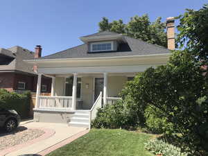 Bungalow-style home featuring an electric vehicle charger and south-facing covered porch