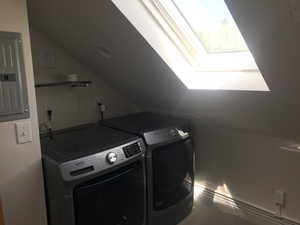 Washroom featuring separate washer and dryer, baseboard heating, electric panel, and a skylight