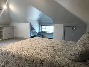 Unfurnished bedroom featuring vaulted ceiling, carpet floors, and a closet. Siting areea ith view.