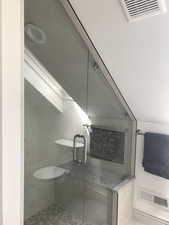 Bathroom featuring a stall shower with skylight. Heatted tile floors.
