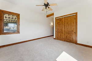 Unfurnished bedroom featuring carpet flooring, a closet, and ceiling fan