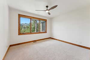 Unfurnished room featuring carpet floors and ceiling fan