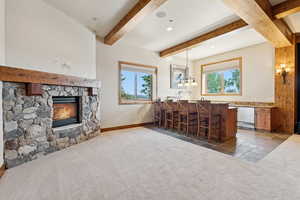Bar featuring carpet, a fireplace, beamed ceiling, pendant lighting, and recessed lighting