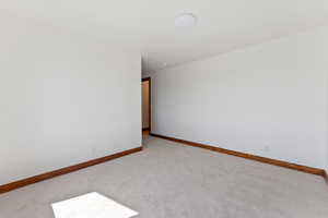 Spare room with baseboards and carpet floors