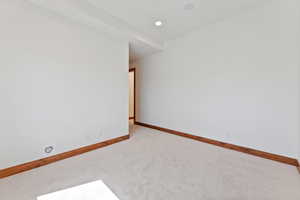 Empty room with recessed lighting and light carpet