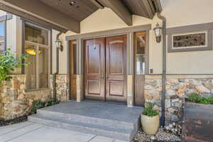 Doorway to property with stone siding and stucco siding