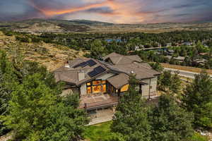 Aerial view at dusk of view of wooded area and a water and mountain view