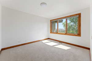 Empty room featuring baseboards and carpet floors