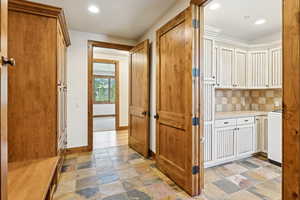 Hallway featuring recessed lighting and light stone finish flooring