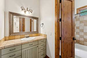 Bathroom featuring vanity and shower / bathtub combination
