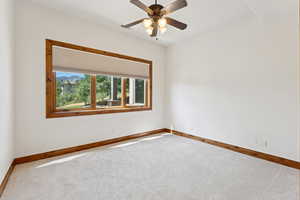 Carpeted spare room featuring baseboards and ceiling fan