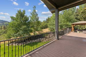 Wooden deck with a gazebo and a yard