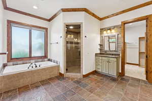 Bathroom with crown molding, vanity, plenty of natural light, a shower stall, and a bath