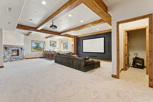 Carpeted cinema room with beam ceiling, a fireplace, and recessed lighting