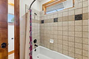 Bathroom with healthy amount of natural light and shower / bath combo