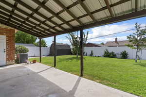 Fenced backyard with a patio area and a storage unit