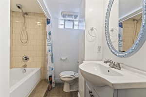 Bathroom featuring vanity and shower / bath combination with curtain