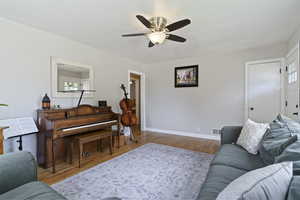 Living area featuring wood finished floors and ceiling fan