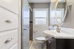 Bathroom with a wainscoted wall, vanity, plenty of natural light, and a shower stall