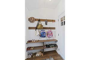 Mudroom featuring wood finished floors and vaulted ceiling