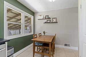 Dining room with light tile patterned flooring and baseboards